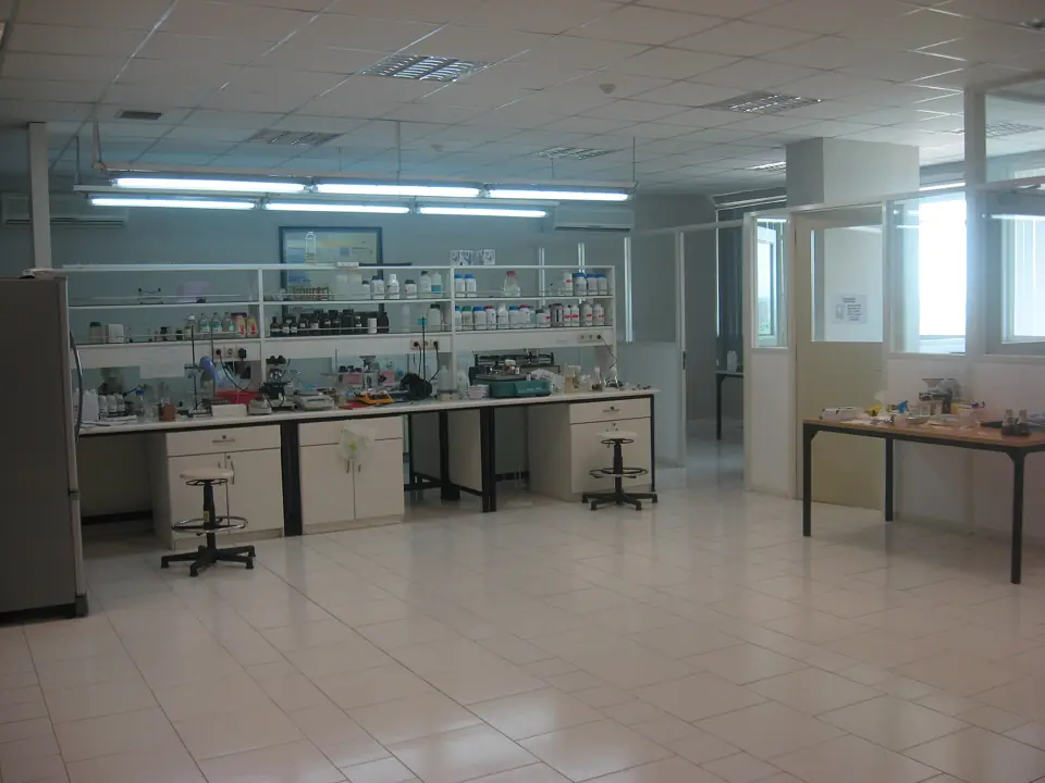 A food microbiology laboratory with benches, stools and shelves of reagents