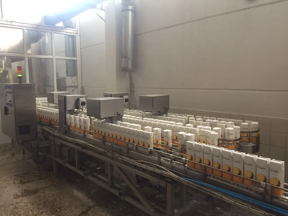 Cartons of juice moving along a packing conveyor in a juice factory