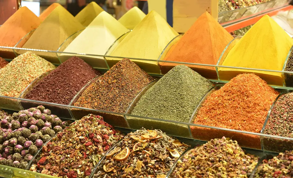 Heaps of colourful ground spices and dried herbs on a market stall