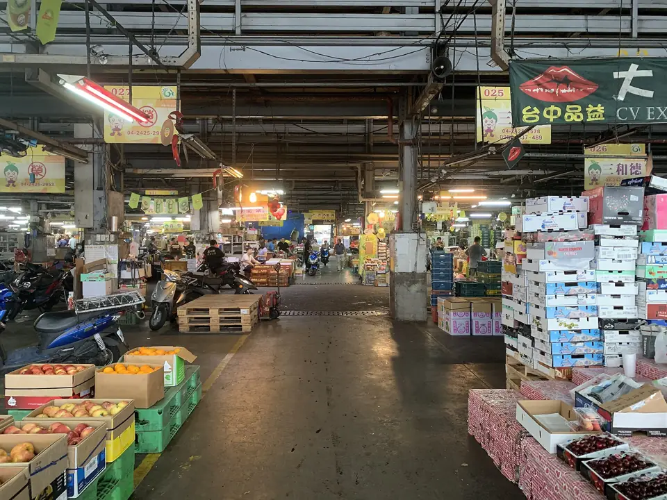 Aisle of a wholesale fruit and vegetable market with stacked fruit boxes